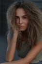 Charming portrait of a beautiful curly woman on the street.