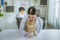 portrait of a beautiful asian female veterinarian with cat on diagnosis table at clinic
