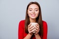 Charming, pretty, nice, cute, lovely woman in casual outfit, having cup of beverage in hands, enjoying smell with close Royalty Free Stock Photo