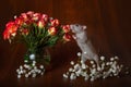 Charming rat on its hind legs sniffs flowers. Brown background