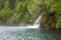 Charming scene of Brienz lake with waterfall and fresh green forest for background