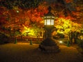 Charming scene of japanese stone lantern are shining on colorful maple trees background at night time Royalty Free Stock Photo