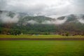 Charming scene of small village under the mountains with mist for background Royalty Free Stock Photo