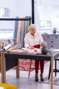 Charming silver-haired aging executive working at the table in office. Royalty Free Stock Photo