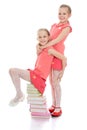 Charming sisters frolic sitting on a stack of Royalty Free Stock Photo