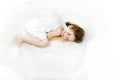 Charming sleeping little girl angel on soft white fur, isolated on white background. Royalty Free Stock Photo