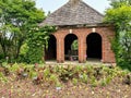 Small brick building with doorway arches at garden