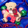 Charming small teddy bear with Christmas gift Royalty Free Stock Photo