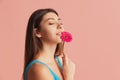 Half-length portrait of pretty girl with flower gerbera posing isolated over pink studio background. Natural beauty Royalty Free Stock Photo