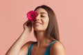 Half-length portrait of pretty girl with flower gerbera posing isolated over pink studio background. Natural beauty Royalty Free Stock Photo