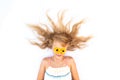 charming smiling child with healthy and strong long blond hair and yellow gerbera flowers on eyes Royalty Free Stock Photo