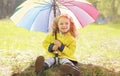 Charming smiling little girl with colorful umbrella