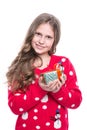 Charming smiling little girl with curly hairstyle wearing red knitted sweater and holding christmas gift isolated on white. Royalty Free Stock Photo