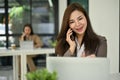 Charming Asian businesswoman recommending a new promotion to her client on the phone Royalty Free Stock Photo