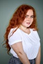 Charming smiling plus size young redhaired girl posing studio