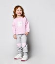 Charming smiling red-haired little girl in sportswear