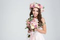 Charming smiling young bride in flower wreath with beautiful bouquet