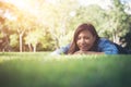 Charming smiling young hipster woman lying on green grass. Royalty Free Stock Photo