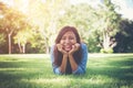 Charming smiling young hipster woman lying on green grass. Royalty Free Stock Photo