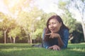 Charming smiling young hipster woman lying on green grass. Royalty Free Stock Photo