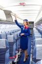Charming Stewardess Dressed In Uniform in the passenger cabin of the aircraft. Russia, Saint-Petersburg. 23 November, 2017.