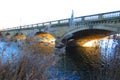 Charming stoned bridge with arcs at sunrise.