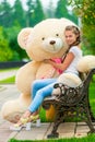 Charming stylish girl on a bench with a teddy bear