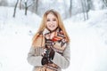 Charming sweet young girl in a winter stylish coat in a vintage wool scarf in stylish warm mittens