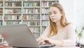 Charming teen girl working on her computer at the library Royalty Free Stock Photo