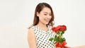 Charming tender girl holds red roses in her hands and looks thoughtfully to the side. Photo on a white background