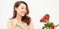 Charming tender girl holds red roses in her hands and looks thoughtfully to the side. Photo on a white background