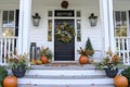 A charming Thanksgiving themed front porch with pumpkins, wreaths, and seasonal flowers Royalty Free Stock Photo