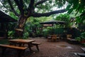 Charming tropical cafe setting showcasing a large tree and a peaceful backyard oasis for relaxation Royalty Free Stock Photo