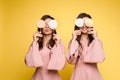 Charming twins eyes with lollipops and posing