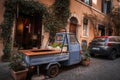 European City Urban Charm Blue Truck with Flowers on Cobblestone Street Royalty Free Stock Photo