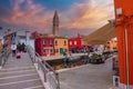 Charming Venice: Man walking along colorful canal and traditional buildings in picturesque scene