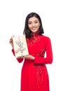 Charming Vietnamese Woman in Red Ao Dai Traditional Dress holding Gift box. Royalty Free Stock Photo