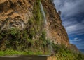 Charming waterfall with water falling directly on a road