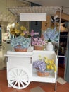 Charming White Decorative Pushcart Displaying Pastel Artificial Flowers Royalty Free Stock Photo