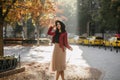 Charming white girl in romantic outfit dreamy posing in september day. Outdoor glad european lady in beige skirt