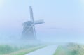 Charming windmill in dense fog