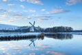 Charming windmill reflected in river water