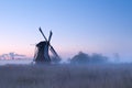 Charming windmill in sunrise fog