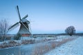 Charming windmill in winter at sunrise