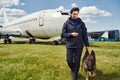 Female security officer with dog walking down airfield Royalty Free Stock Photo