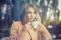 Charming woman with beautiful smile reading good news on mobile phone during rest in coffee shop, happy Caucasian female watching Royalty Free Stock Photo