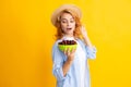 Charming woman with cherry plate isolated on yellow. Royalty Free Stock Photo