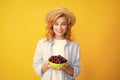 Charming woman with cherry plate isolated on yellow. Royalty Free Stock Photo