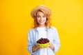 Charming woman with cherry plate isolated on yellow. Royalty Free Stock Photo