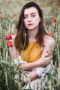 Charming woman in field of red poppy